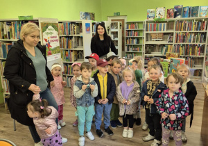 Dzieci stoją przy regałach z książkami