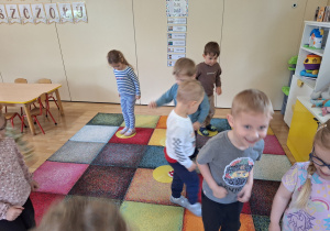 dzieci stoją na żółtych kołach