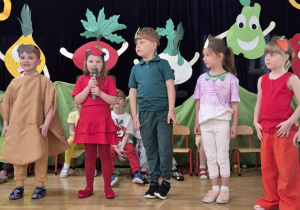 Dzieci w przebraniach stoją na scenie