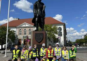 Dzieci pozują przed pomnikiem Marszałka Józefa Piłsudskiego.