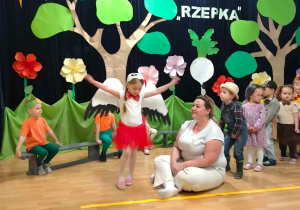 dziewczynka macha rękoma udając bociana