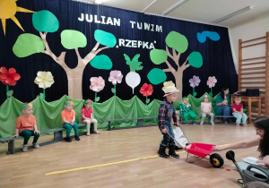 chłopiec prowadzi taczki