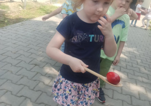 dziewczynka przechodzi między pachołkami z jajkiem na łyżce