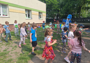 dzieci razem z delfinkiem robią rozgrzewkę