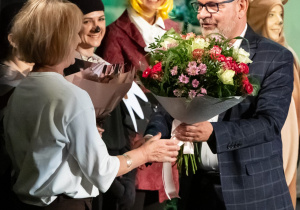 Pan Naczelnik składa kwiaty na ręce Pani Dyrektor.
