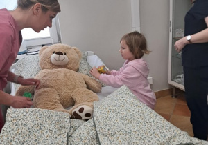 Dziewczynka bada pluszowego misia.