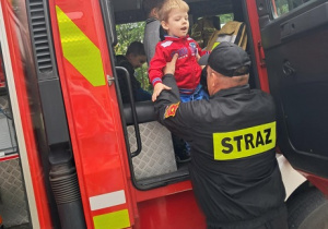 Chłopiec ogląda wóz strażacki.