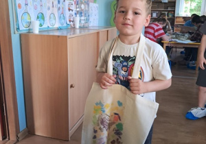 Chłopiec prezentuje wykonaną przez siebie z pomocą mamy torbę.
