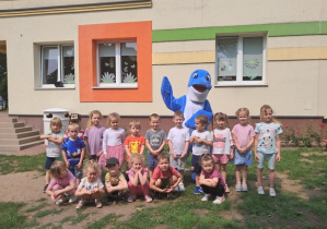 Dzieci pozują do zdjęcia wraz z delfinkiem.