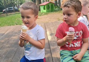 Chłopcy jedzą lody.