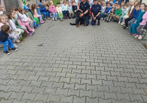 policjanci wraz z psem pozują do zdjęcia