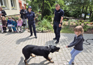 Dziecko bawi się z psem policyjnym