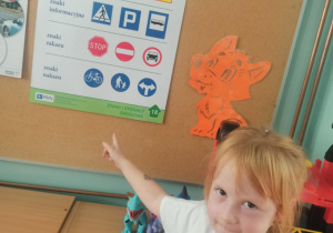 dziewczynka wskazuje na znaki drogowe