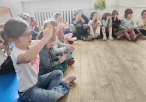 Dzieci wspólnie z Panią psycholog uczą się słów w języku migowym