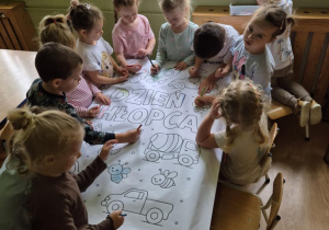 Dzieci kolorują wspólnie obrazek