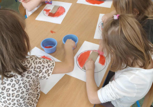 Dzieci wykonuja pracę plastyczną.