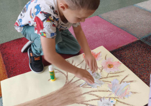 Chłopiec przykleja swoją karteczkę z narysowaną super mocą.