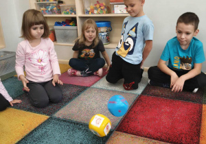 Dzieci uczestniczą w grze przy użyciu dużych kostek do gry.