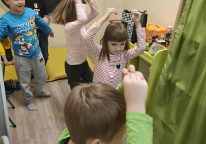 Dzieci wykonuja ćwiczenia ruchowe.