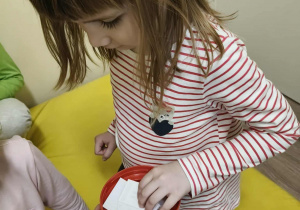 Dziewczynka losuje kartkę z daną aktywnoscią.