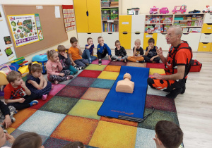 Dzieci utrwalają z ratownikiem medycznym numery alarmowe.