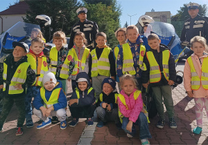 Dzieci pozują do wspólnego zdjecia z funkcjonariuszami policji.