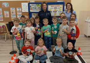 Dzieci pozują do zdjęcia z policjantką.