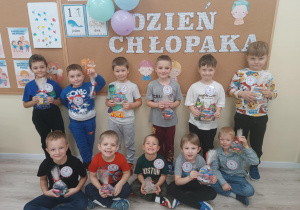 Chłopcy pozują do zdjęcia z upominkami.