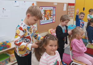 Chłopcy zaplatają dziewczynką warkocze na czas.