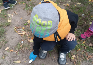 Chłopiec sprząta śmieci.