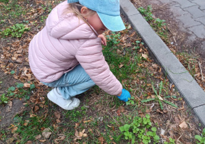 Dziewczynka sprząta śmieci.