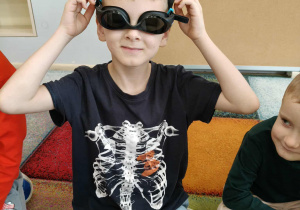 Chłopiec w okularach pływackich.