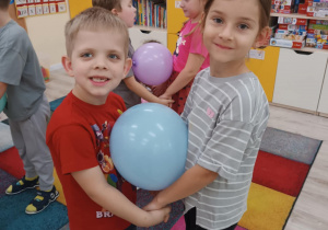 Dzieci tańczą w parach z balonem.