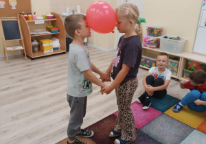 Dzieci tańczą w parach z balonem.