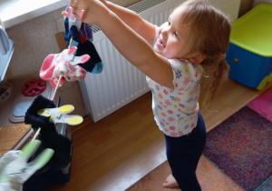 Dziewczynka wiesza skarpety na sznurku.