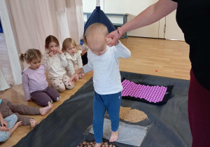 Chłopiec idzie po ścieżce sensorycznej.