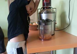 Chłopiec wyciska sok przez sokowirówkę
