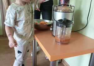 Dziewczynka wyciska sok przez sokowirówkę