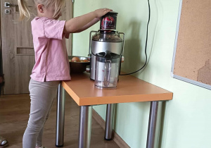 Dziewczynka wyciska sok przez sokowirówkę