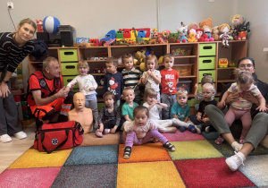 Dzieci pozują do zdjęcia z ratownikiem medycznym