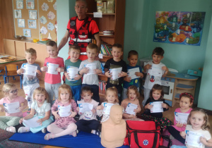 Dzieci pozują do zdjęcia z ratownikiem medycznym