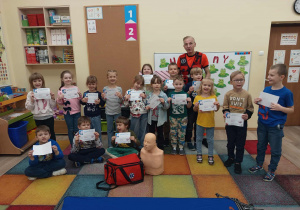 Dzieci pozują do zdjęcia z ratownikiem medycznym