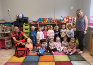 Dzieci pozują do zdjęcia z ratownikiem medycznym