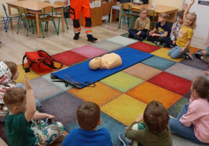 Dzieci słuchają ratownika medycznego