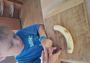 chłopiec kroi banana