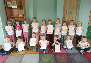 dzieci pozują do zdjęcia z pracami