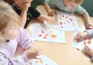 dzieci układają bibułę na kartkę