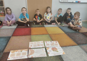 Dzieci obserwują tablice demonstracyjne na temat dyni.