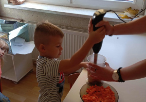 Chłopiec blenduje marchew.