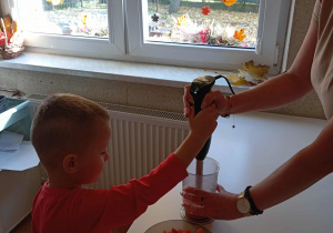 Chłopiec blenduje marchew.